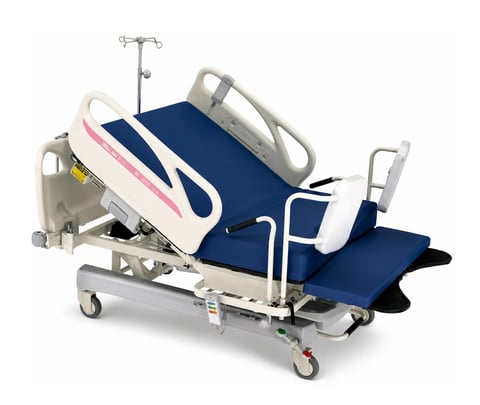 Medical exam table with blue cushioned surface, side rails, and adjustable head section on wheels with IV stand