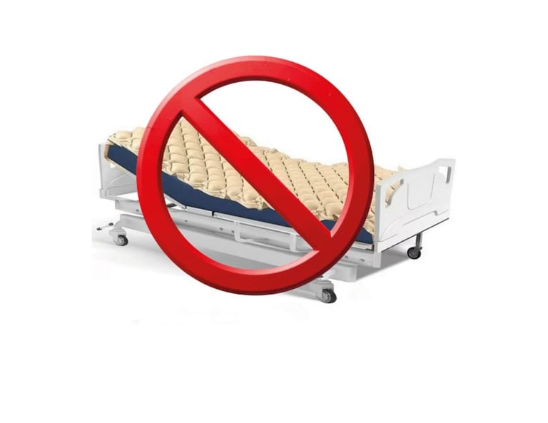 Hospital bed with mattress crossed out by red prohibition symbol